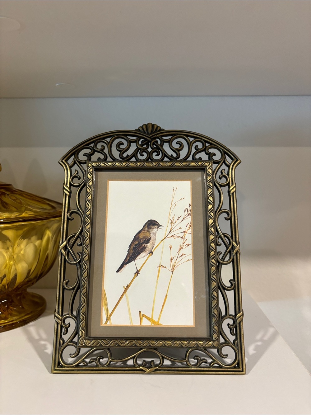 Ornate bronze coloured metal frame.